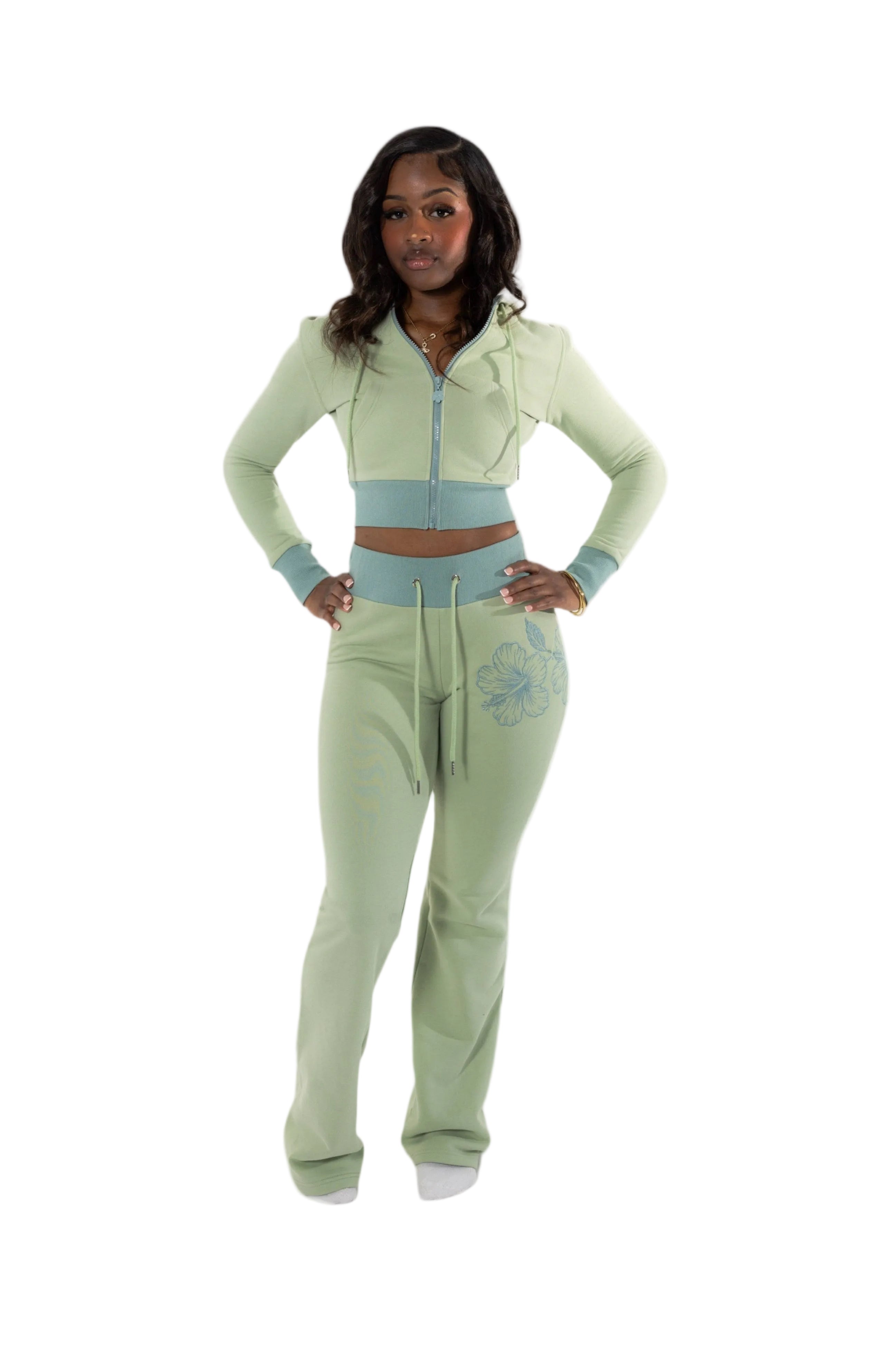 Woman wearing a green and light blue tracksuit on a white background