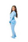 Woman wearing a light blue outfit with floral designs on a white background