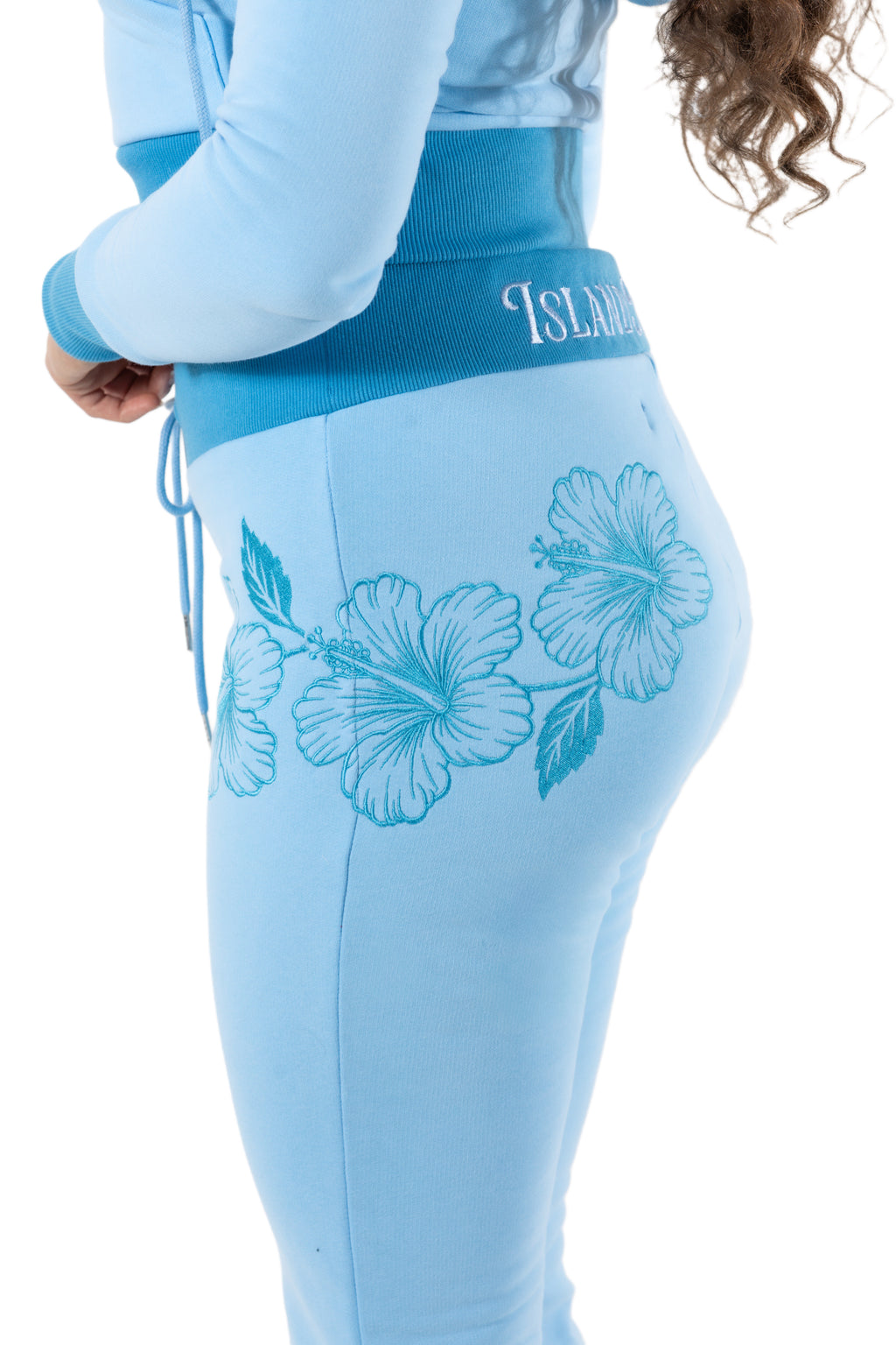 Light blue leggings with floral designs and 'Island' text on a white background