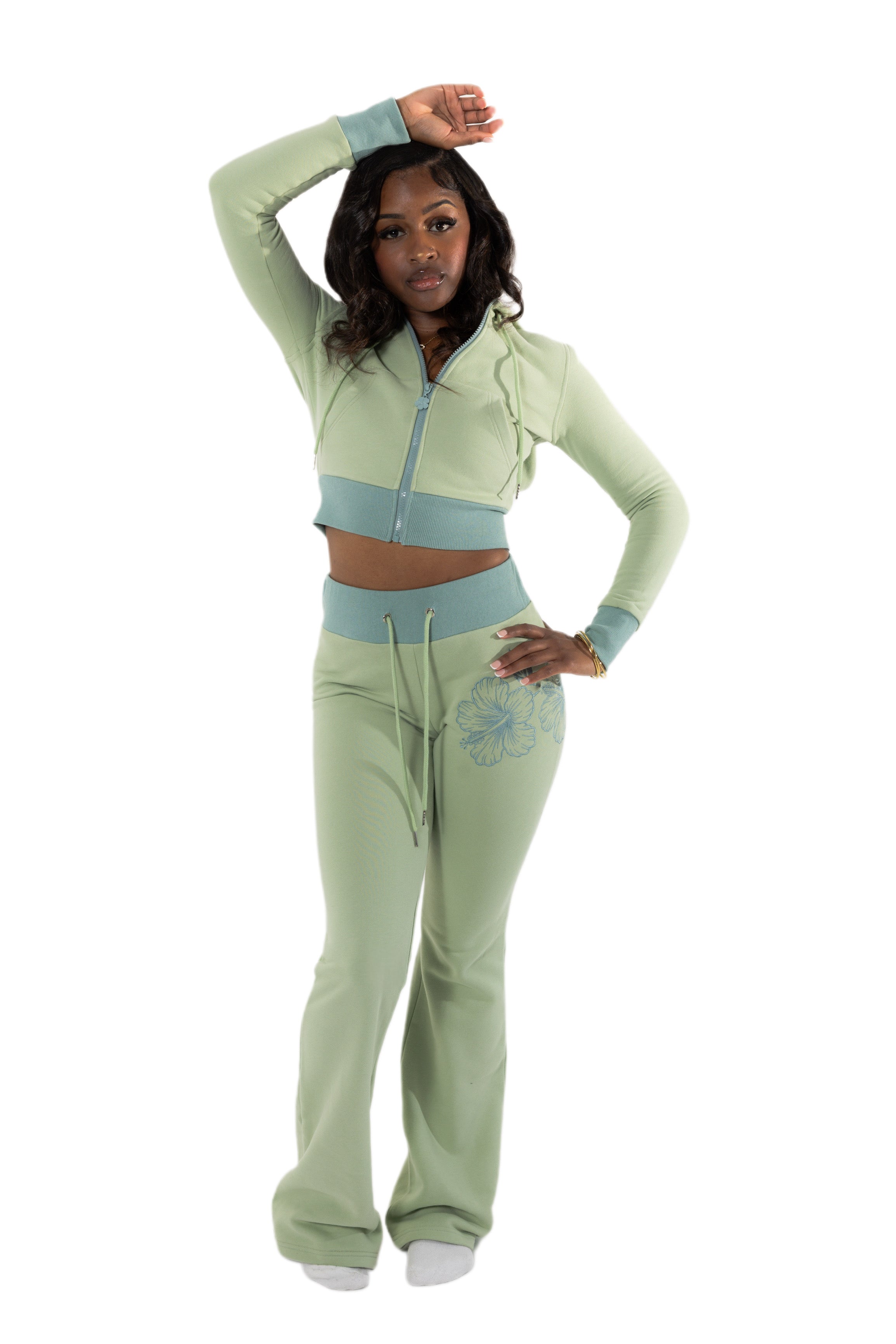 Woman wearing a green tracksuit with a white background